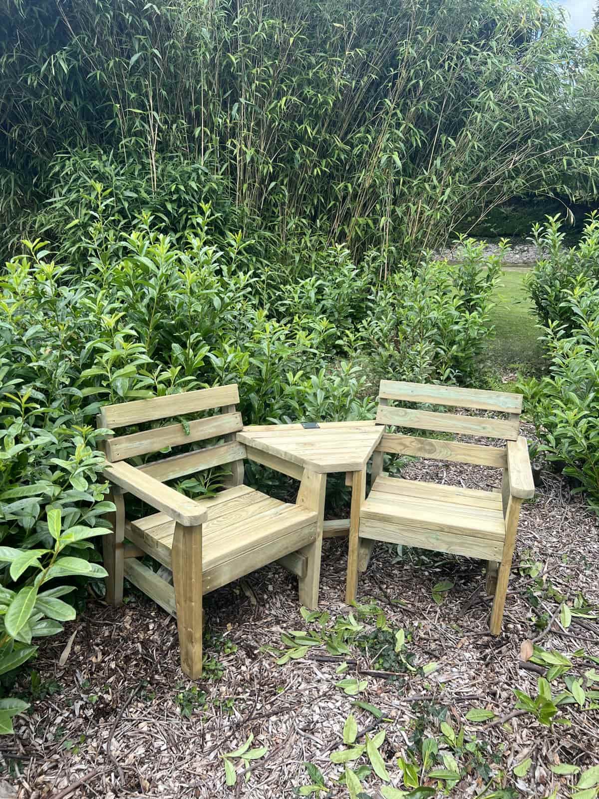 A love chair, two angled timber seats with a table between them